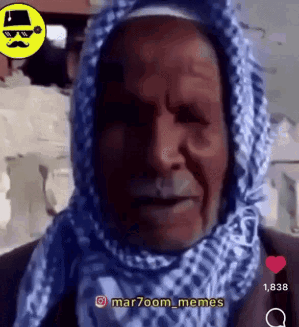 a man wearing a scarf and sunglasses is talking to someone .