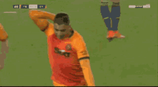 a group of soccer players wearing orange jerseys celebrate a goal