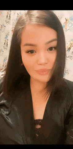 a woman in a black top is looking at the camera