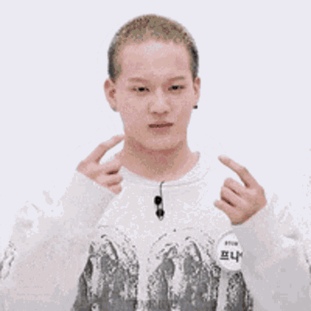 a young man wearing a white sweater and a name tag with chinese writing on it .