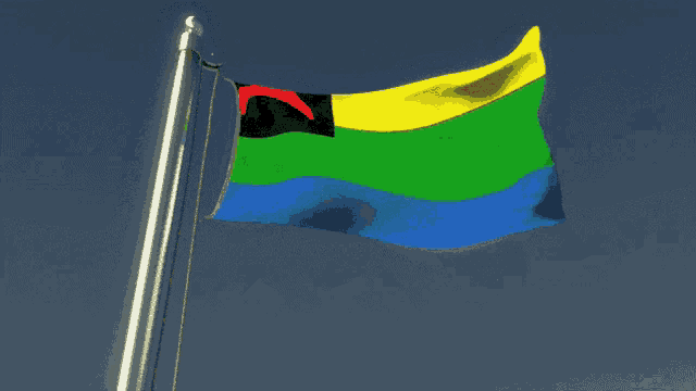 a colorful flag is waving in the wind with a blue sky in the background