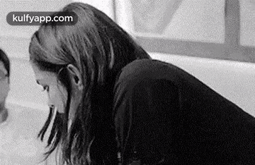 a woman is sitting in a bathtub with her eyes closed .