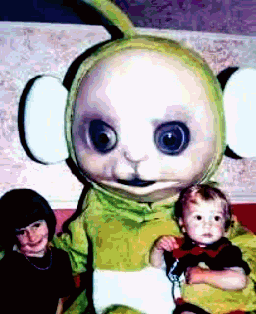 a child is holding a stuffed animal that looks like a teletubbies character