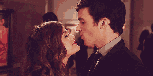 a man and a woman are kissing in front of people