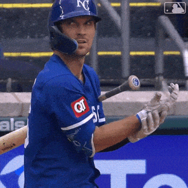 a baseball player wearing a kc helmet holds his bat