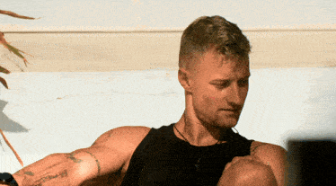 a man in a black tank top has a tattoo on his arm that says ' i love you ' on it