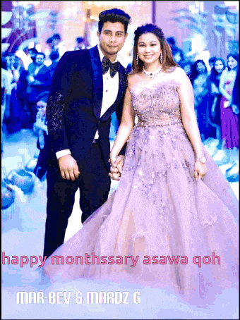 a man in a tuxedo and a woman in a purple gown holding hands