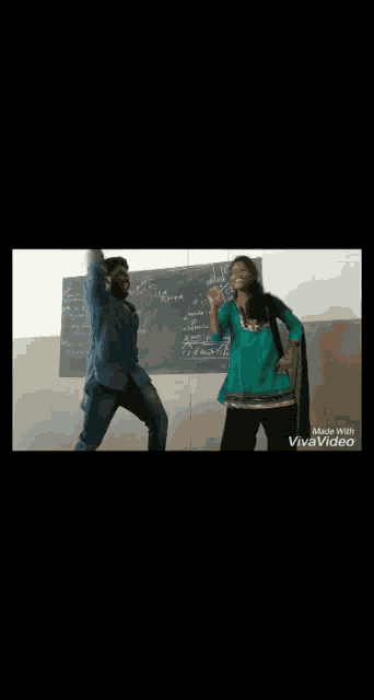 a man and a woman are dancing in front of a chalkboard .