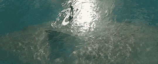 an aerial view of a person on a surfboard in the ocean .