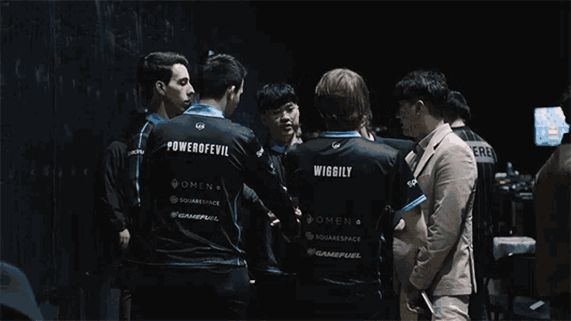 a group of men are huddled together with one wearing a shirt that says wiggilly
