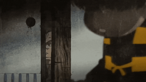 a man in a black and yellow striped shirt is peeking out from behind a door