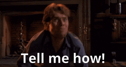 a man is standing in front of a fireplace and says " tell me how "