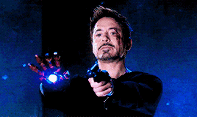 a man with a beard is pointing a gun at something in the dark