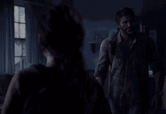 a man and woman are standing in a dark room