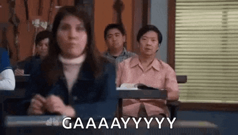 a group of people are sitting in a classroom with a woman sitting at a desk .