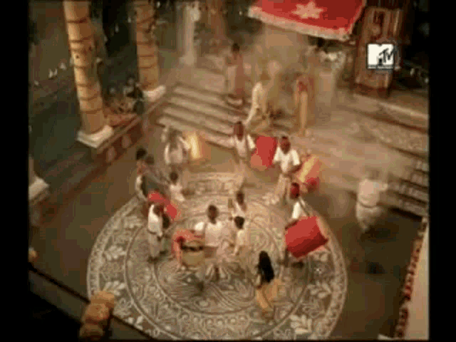 a group of people are dancing in a room with a mtv logo in the corner .