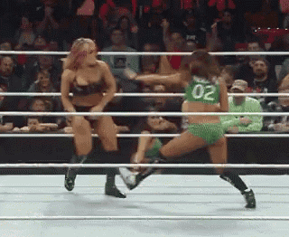 two women are wrestling in a ring and one of them has the number 02 on her shirt