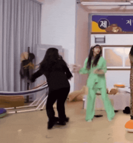 a woman in a green suit is dancing in front of a sign that says ' jee ' on it