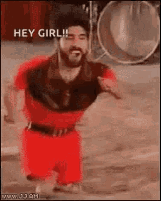 a man with a beard is wearing red shorts and a red shirt and says hey girl .