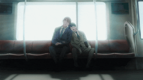two men in suits are sitting next to each other on a subway