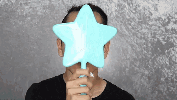 a man covering his face with a star shaped brush