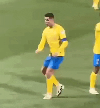 a soccer player wearing a yellow jersey and blue shorts is kicking a ball