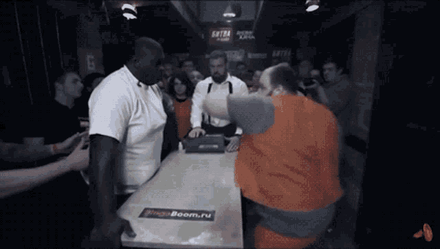 a group of men are standing around a table with a sticker that says ringboom.ru