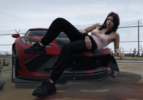 a woman laying on the front of a red car