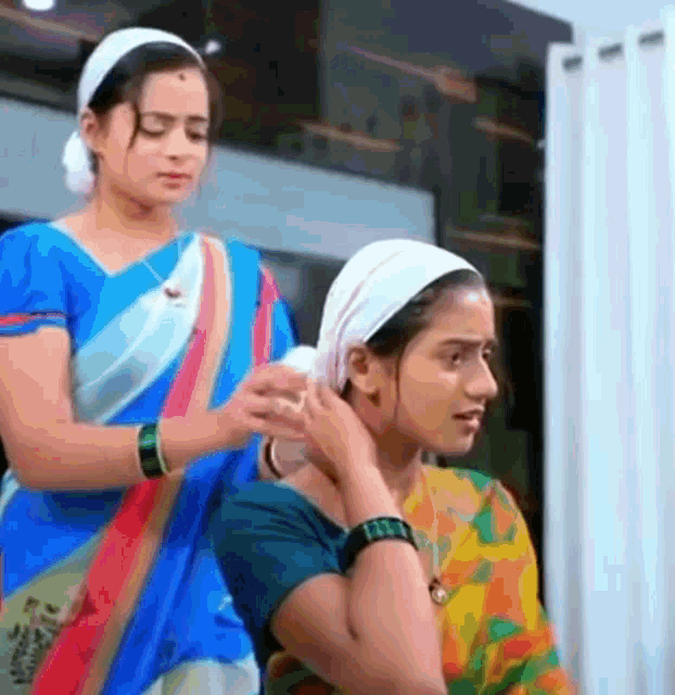 two women are standing next to each other in a room .