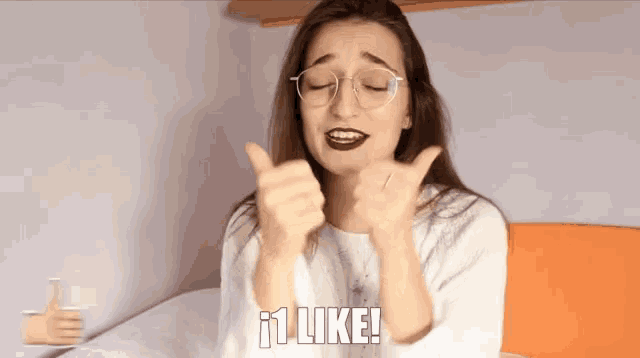 a woman wearing glasses giving a thumbs up with the words like written below her