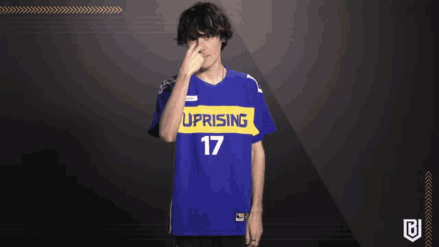 a man wearing a blue shirt with the number 17 covering his nose