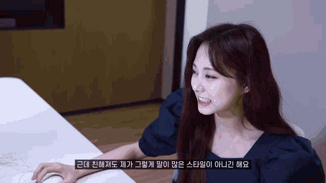a woman is sitting at a table with a foreign language caption