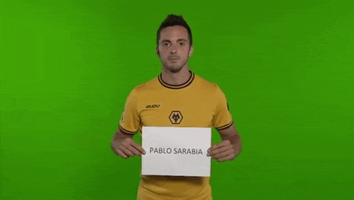 a man in a yellow shirt is holding a sign that says pablo sarabi