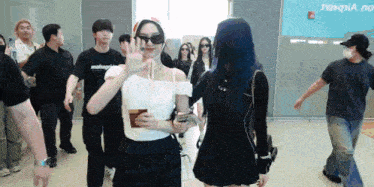 a group of people are walking in front of a sign that says hongqia