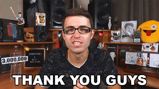 a man with glasses says thank you guys in front of a desk