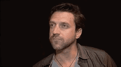 a man is holding his head with his hands while making a funny face .