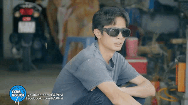 a man wearing sunglasses sits in front of a motorcycle and a facebook logo