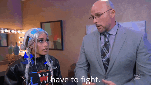 a man in a suit and tie is talking to a woman in a wig who says i have to fight