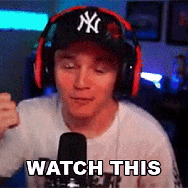 a man wearing headphones and a ny hat is saying watch this
