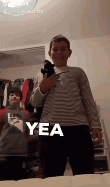 a boy holding a stuffed animal with the word yea in white letters