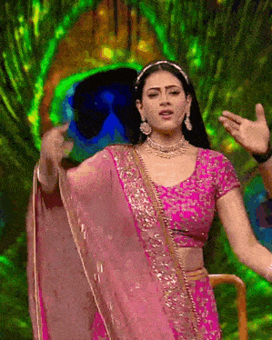 a woman in a pink dress is dancing on a stage .