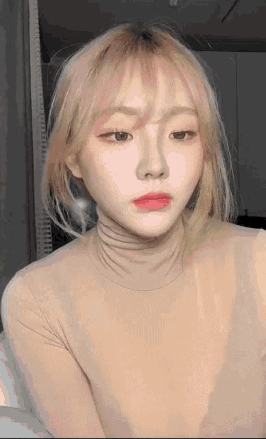 a close up of a woman 's face with a turtleneck