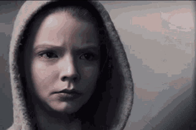 a close up of a girl wearing a hooded sweatshirt .