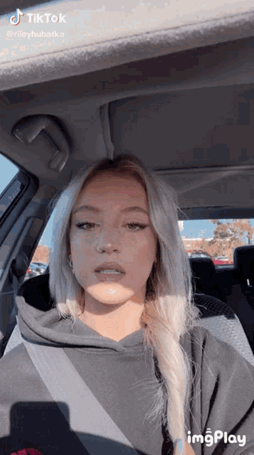 a woman is sitting in the back seat of a car with a tiktok watermark