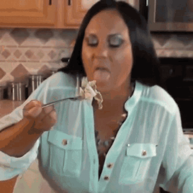 a woman sticking her tongue out while eating a piece of food