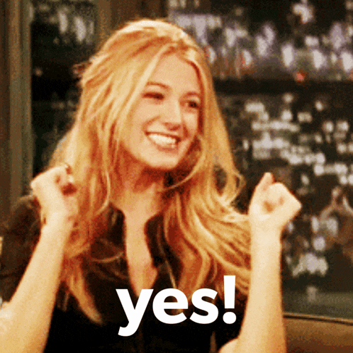 a woman with blonde hair is smiling and holding her fist up in the air with the words yes behind her