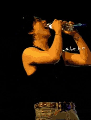 a man singing into a microphone with the word love visible on his shirt