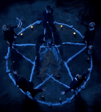a group of people are standing in a pentagram with candles