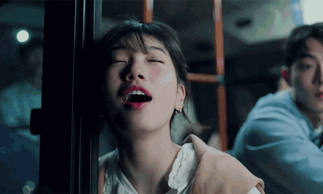 a close up of a woman yawning with her eyes closed