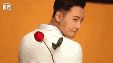 a man is holding a red rose in his back pocket .